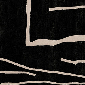 Close view of uneven pale painted lines crossing the black woven surface.