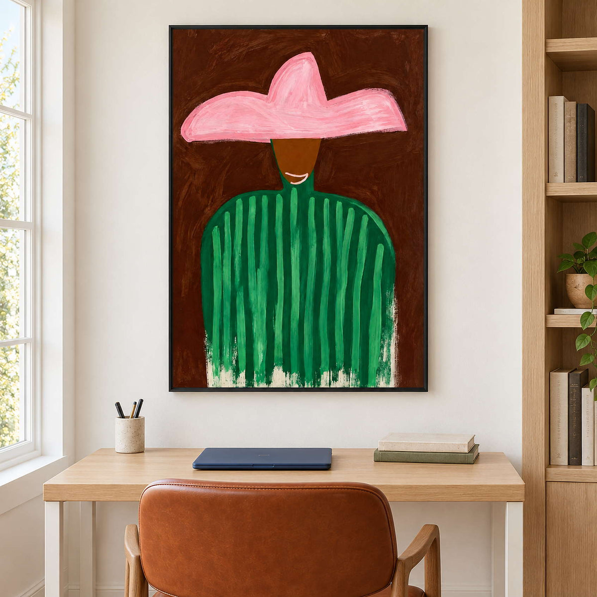 Smiling figure portrait above a light wood desk with a brown chair and bookshelves.