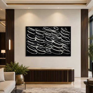 Black framed pale looping artwork above a ribbed console in a hotel lobby.