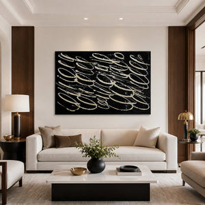 Black and white looping abstract wall art above a cream living room sofa.