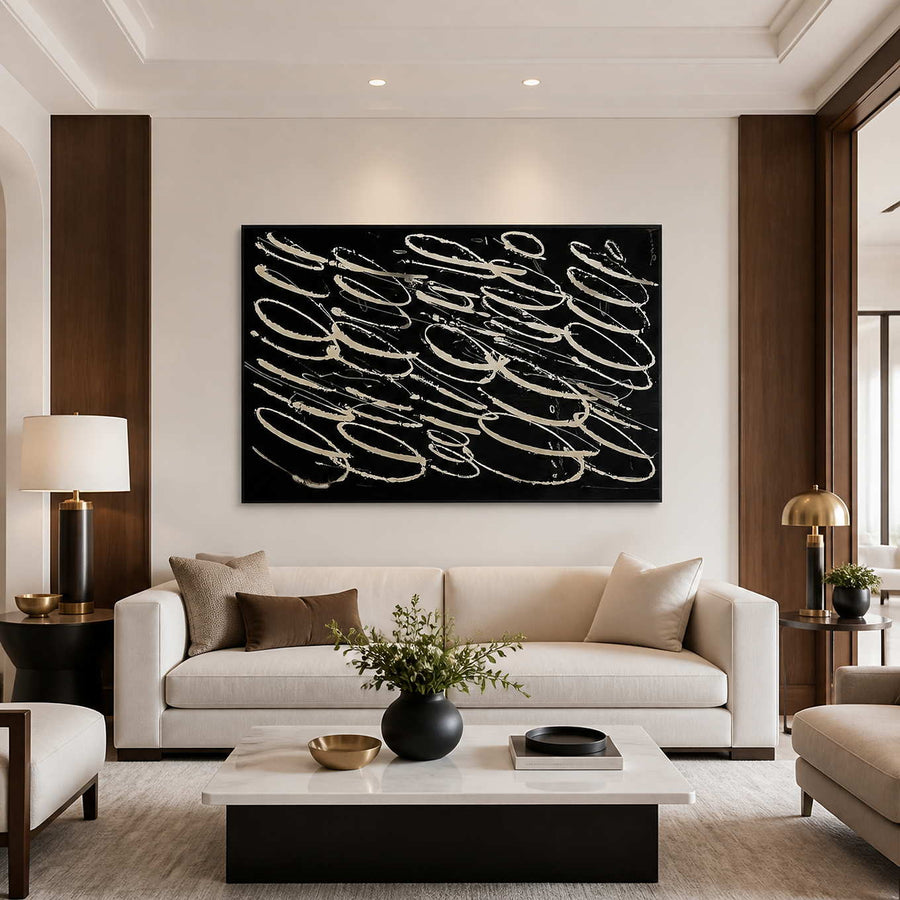 Black and white looping abstract wall art above a cream living room sofa.