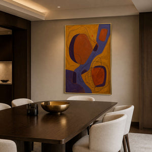 Warm abstract artwork displayed in a dark refined dining room.