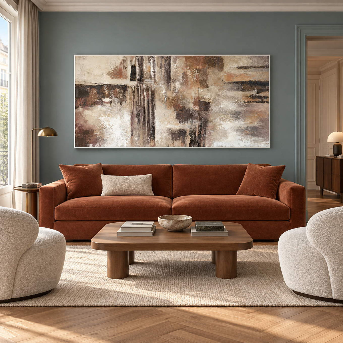Hand-painted abstract wall art in ivory, taupe, umber, and charcoal, displayed in a living room in a white frame.