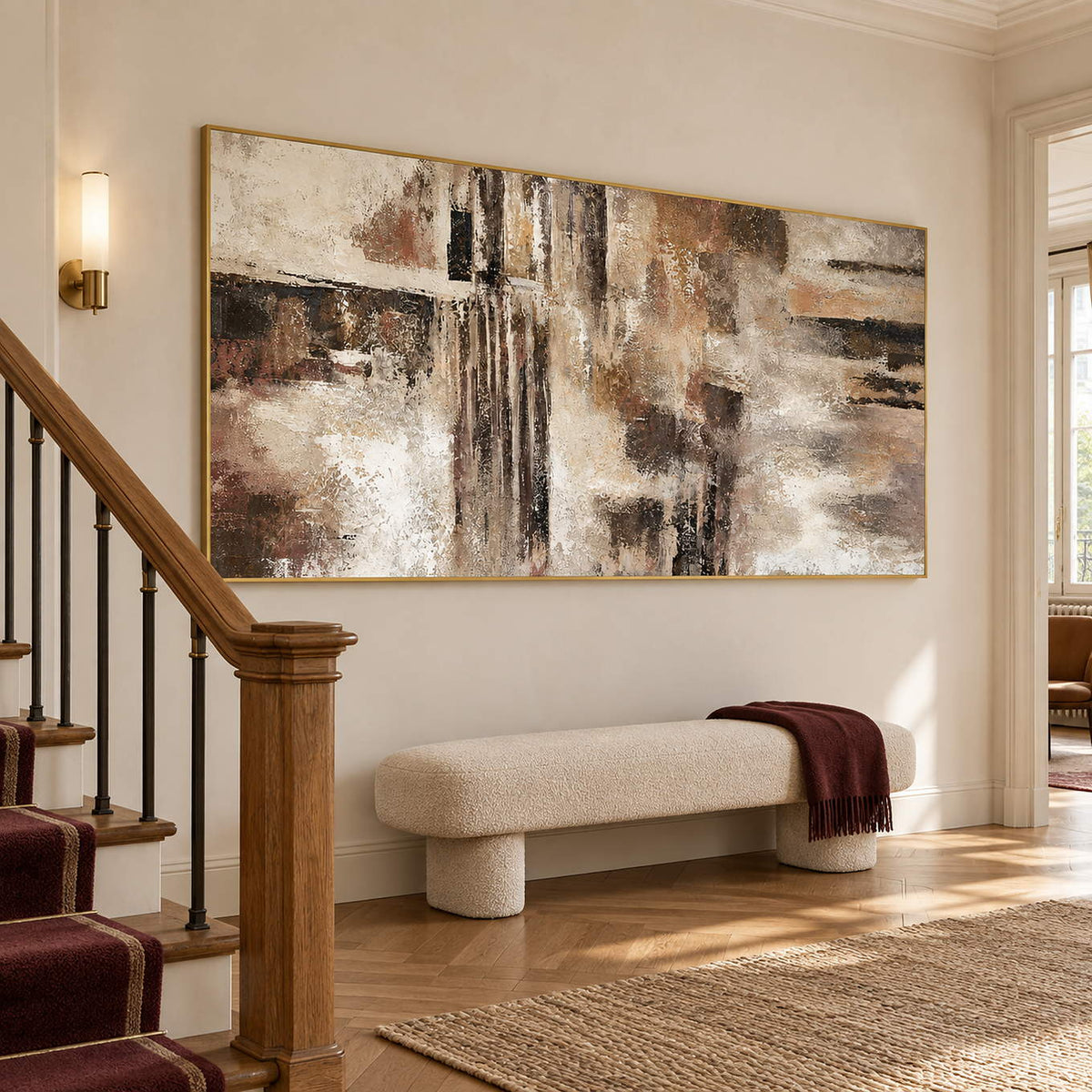 Hand-painted abstract wall art in ivory, taupe, umber, and charcoal, displayed beside a staircase in a gold frame.