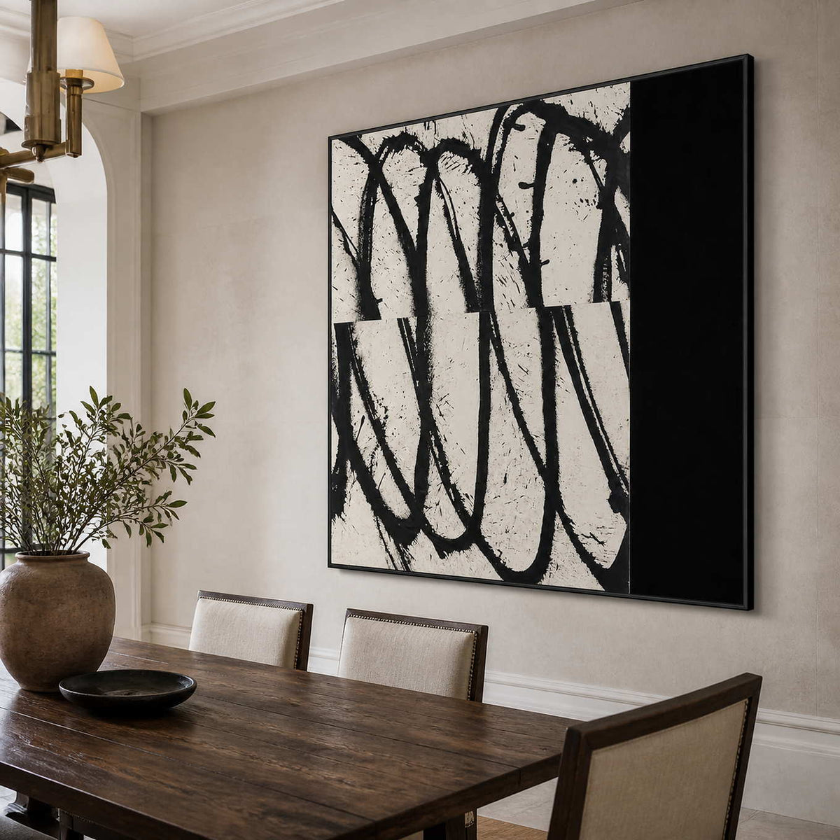Black framed looping abstract artwork above a wooden dining table with pale upholstered chairs.