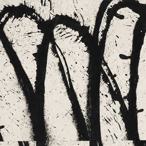 Close view of rough black looping brushwork and scattered marks across an off-white painted surface.