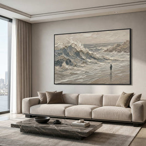 Textured coastal wall art with a solitary figure in a refined living room.