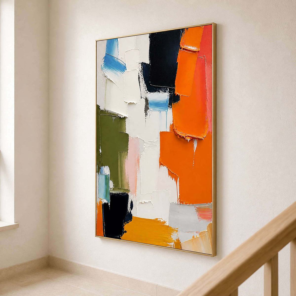 Vertical colorful abstract canvas displayed beside a light wood staircase.