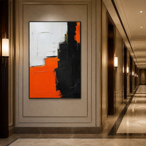 Orange, black, and white abstract wall art displayed along a warm hallway.
