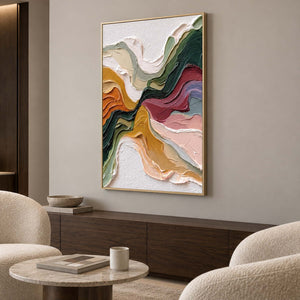 Gold-toned framed flowing artwork above a long wood cabinet between rounded lounge chairs.