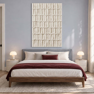 Pale relief-style artwork above a bed with burgundy bedding accents.