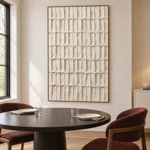 Textured rectangle artwork beside a dark round dining table.