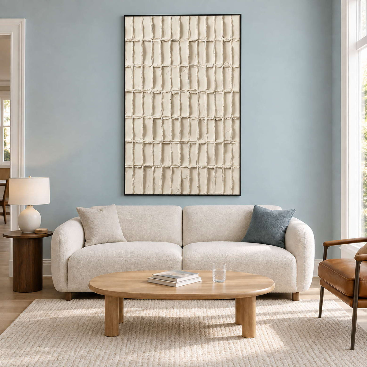 Ivory grid artwork above a cream sofa against a blue wall.