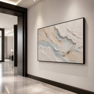 Horizontal textured coastal wall art in a luxury entryway with a black frame.