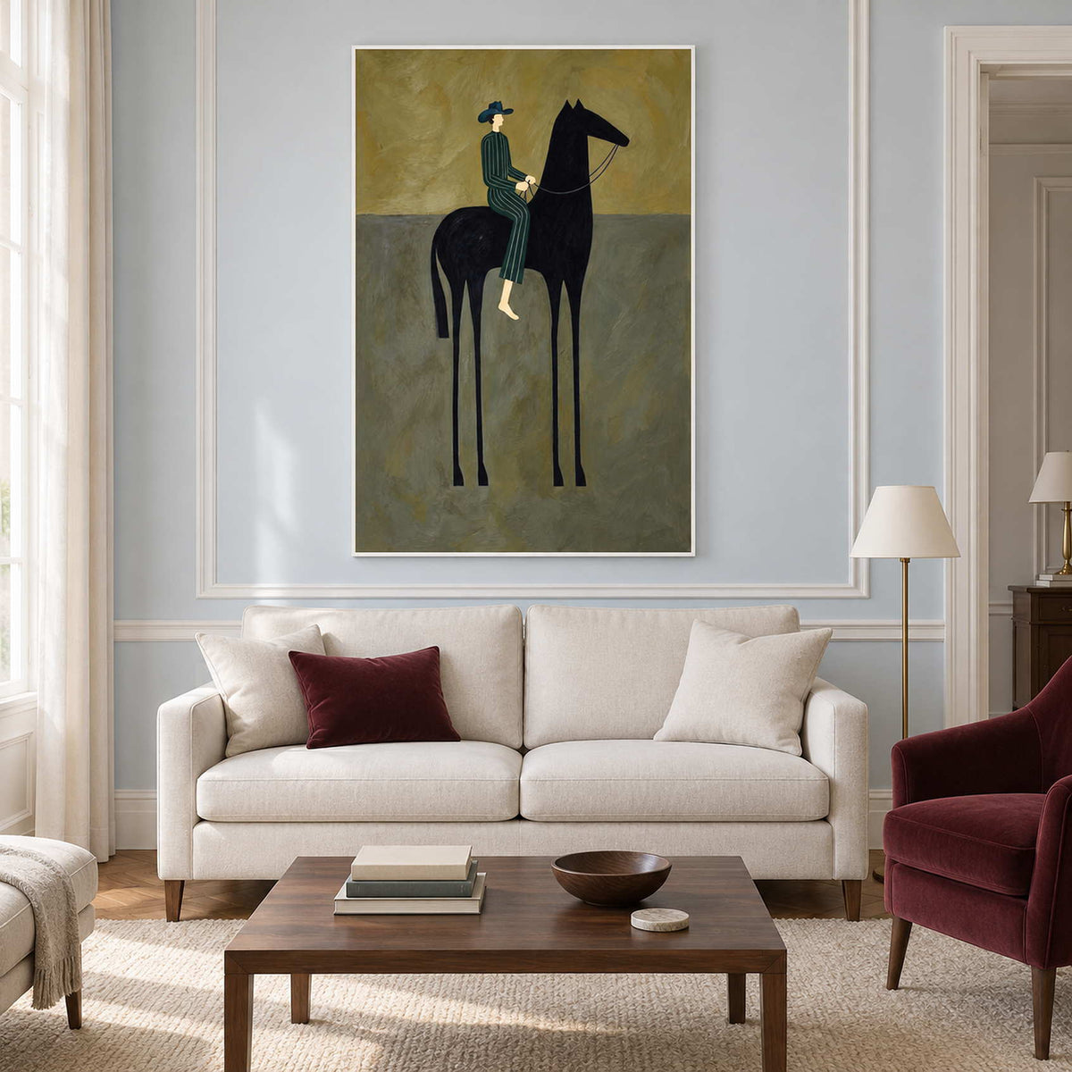 Tall rider-and-horse painting above a cream sofa with burgundy accents.