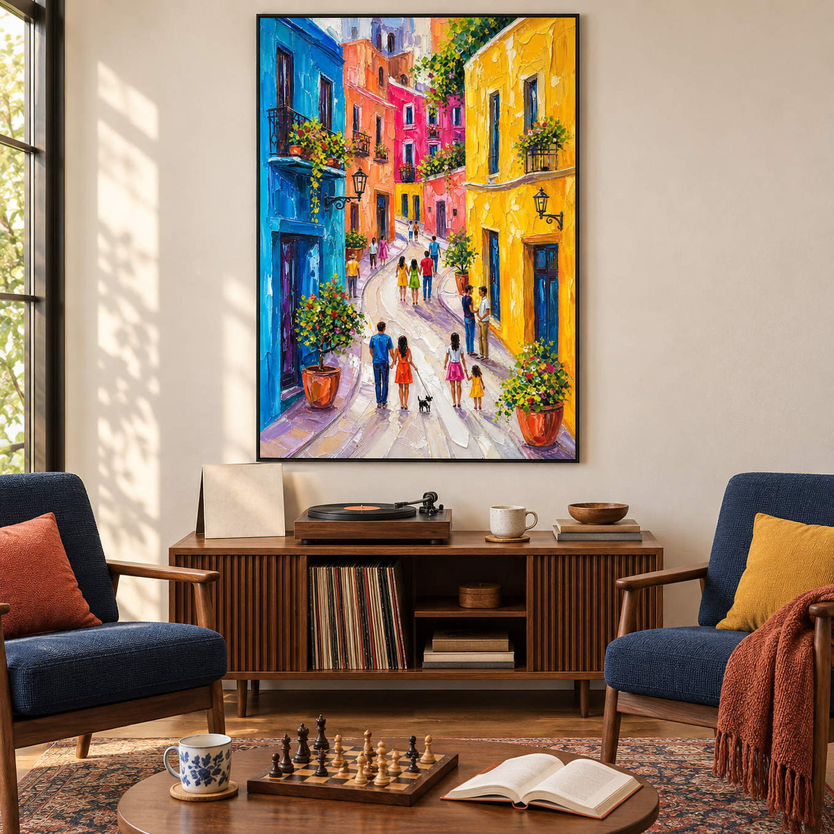Colorful street painting with people, bright facades, and flowered balconies in a black frame in a lounge.