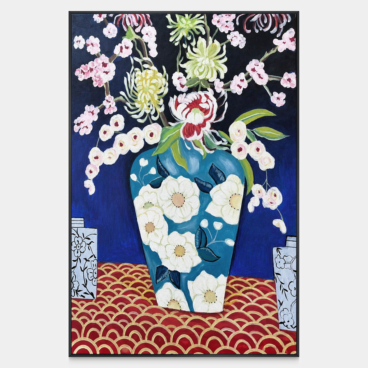 Front view of flowers in a blue floral-patterned vase above a red surface with repeated gold-colored arcs, with a black frame.