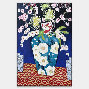 Front view of flowers in a blue floral-patterned vase above a red surface with repeated gold-colored arcs, with a black frame.