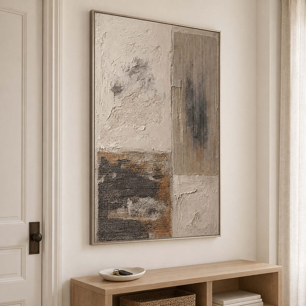 Weathered ivory and beige textures with gray blocks and dark marks in a silver frame, displayed above an entryway console.