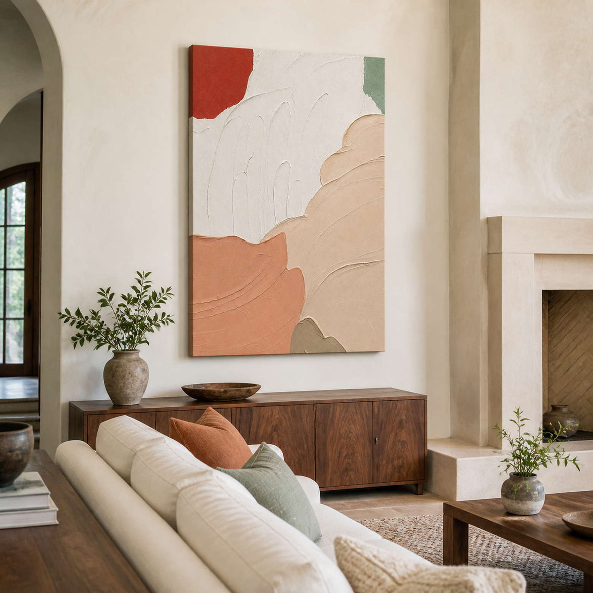 Frameless peach and white textured artwork above a wooden cabinet beside a living room fireplace.