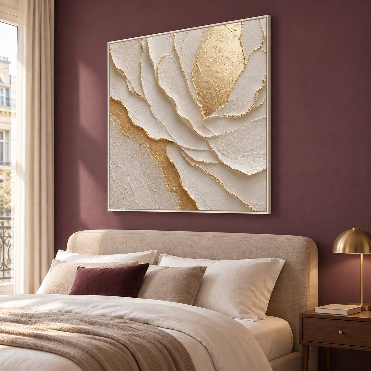 Hand-painted sculptural flower in layered ivory, white, and warm gold, displayed in a bedroom in a white frame.