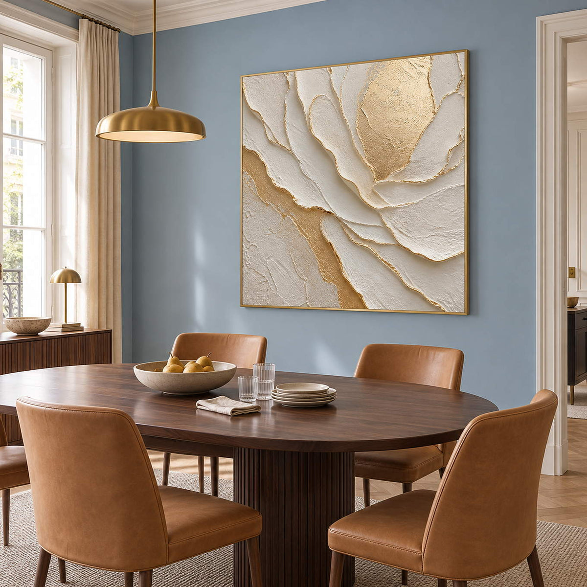 Hand-painted sculptural flower in layered ivory, white, and warm gold, displayed in a dining room in a gold frame.