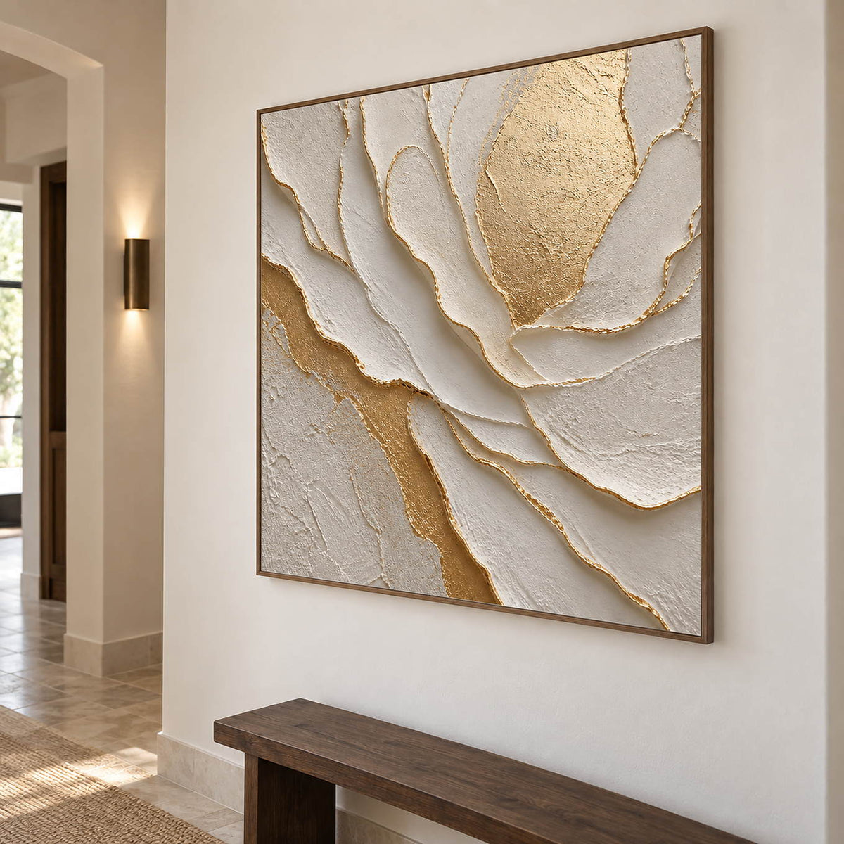Hand-painted sculptural flower in layered ivory, white, and warm gold, displayed in a hallway in a brown wood frame.