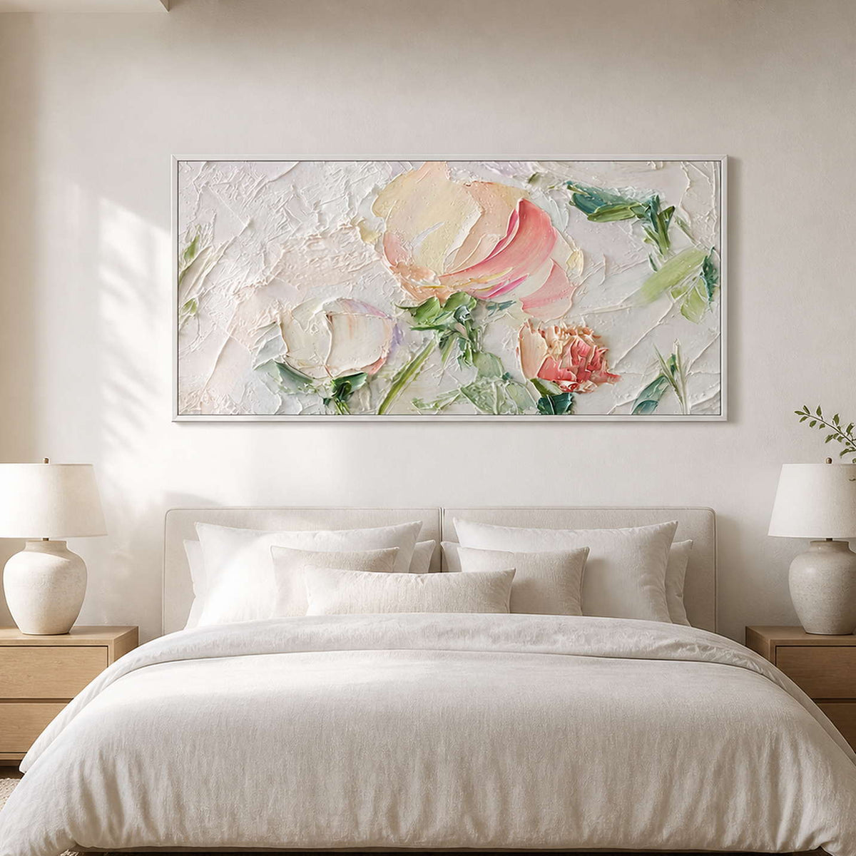 White framed horizontal flowers above a cream upholstered bed between matching lamps.