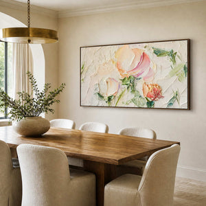 Wood framed floral painting beside a wooden dining table under a circular pendant.