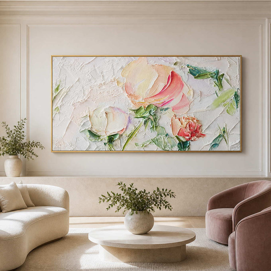 Gold framed pink floral artwork above cream and blush seating around a round table.