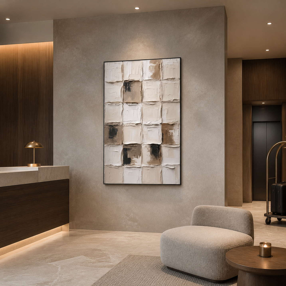 Black framed textured grid painting beside a hotel reception counter and luggage trolley.