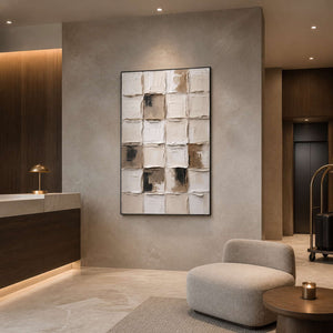 Black framed textured grid painting beside a hotel reception counter and luggage trolley.