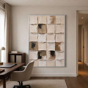 Silver framed neutral abstract grid beside a home office desk and upholstered chair.