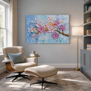 Blush textured painting displayed beside a pale reading chair.