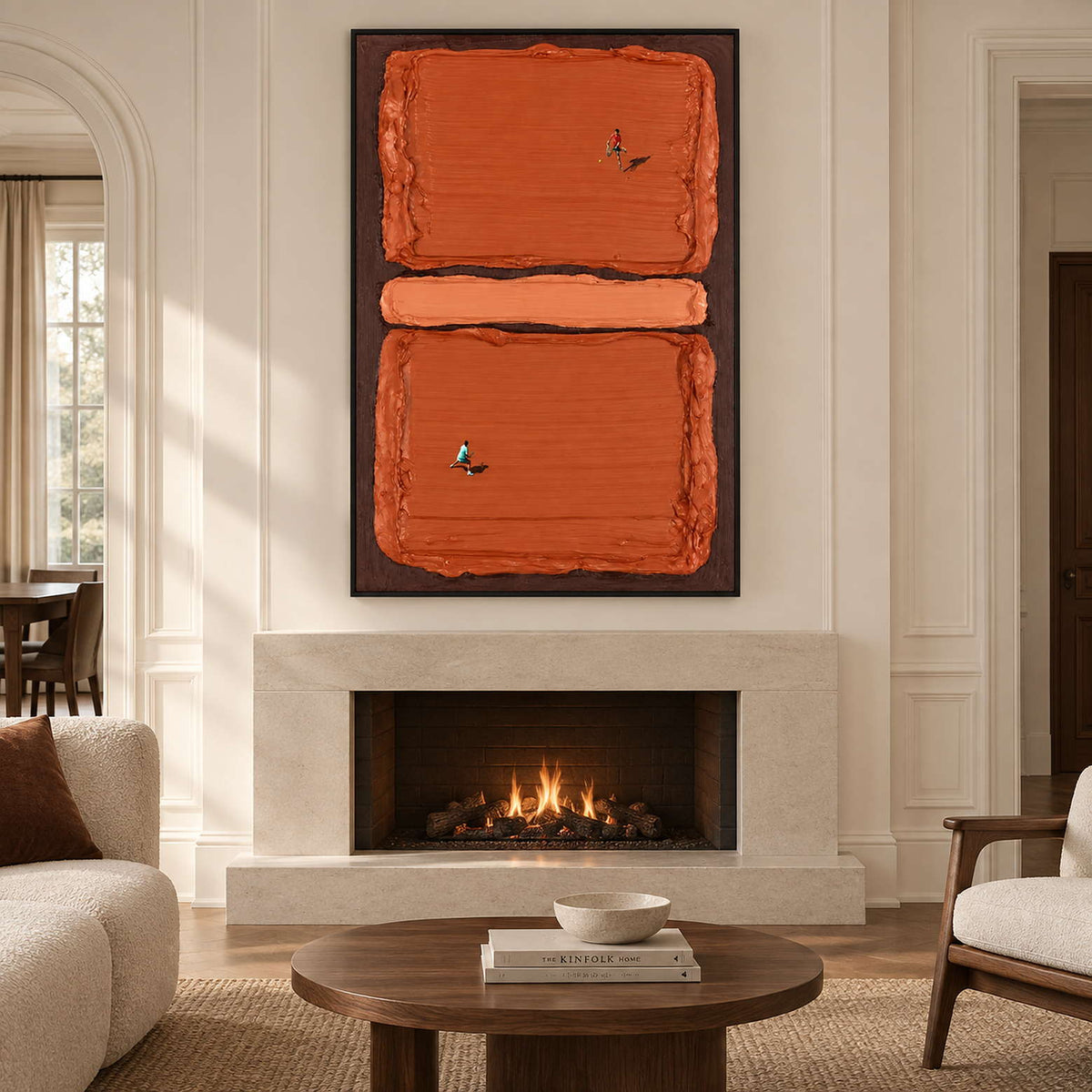 Orange block sports artwork above a lit pale fireplace in a cream-paneled room.