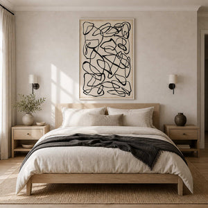 White framed abstract line painting above a pale wooden bed and linen pillows.