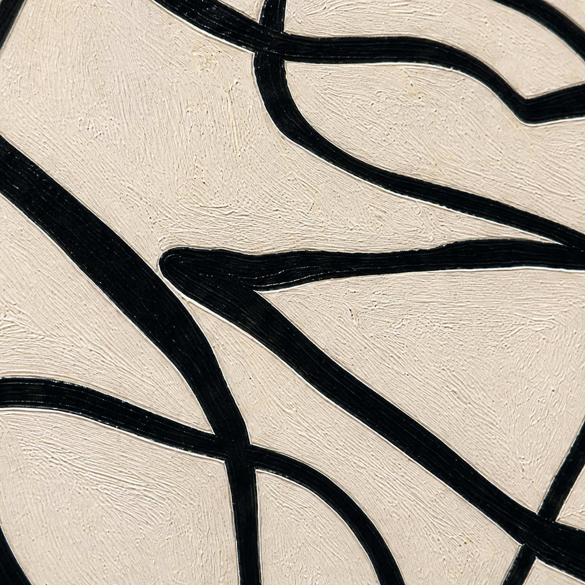 Close view of black curved strokes crossing lightly brushed warm cream paint.