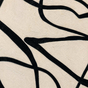 Close view of black curved strokes crossing lightly brushed warm cream paint.