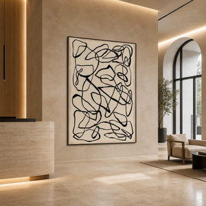Black framed looping artwork near a stone reception desk and arched lobby windows.