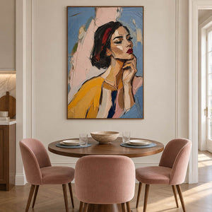 Textured portrait of a dark-haired woman in mustard yellow in a brown wood frame in a dining room.