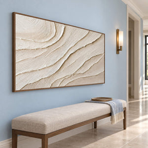 Panoramic ivory abstract wall art with layered flowing relief, displayed in a hallway in a brown wood frame.