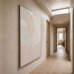 Raised neutral wall art viewed along a warm plaster hallway.