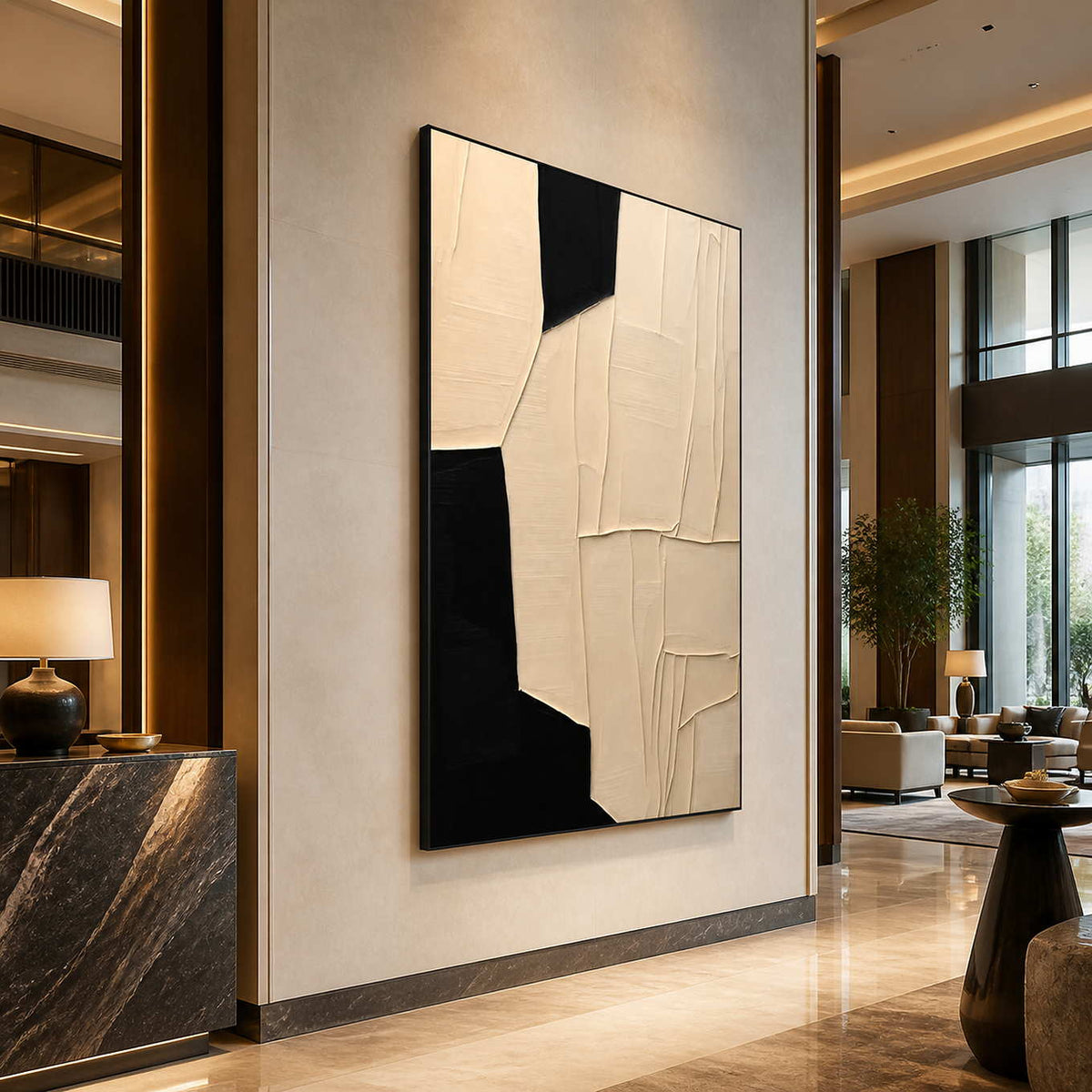 Black framed cream geometric artwork beside a dark stone hotel reception desk.