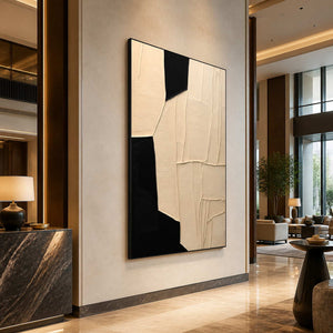Black framed cream geometric artwork beside a dark stone hotel reception desk.