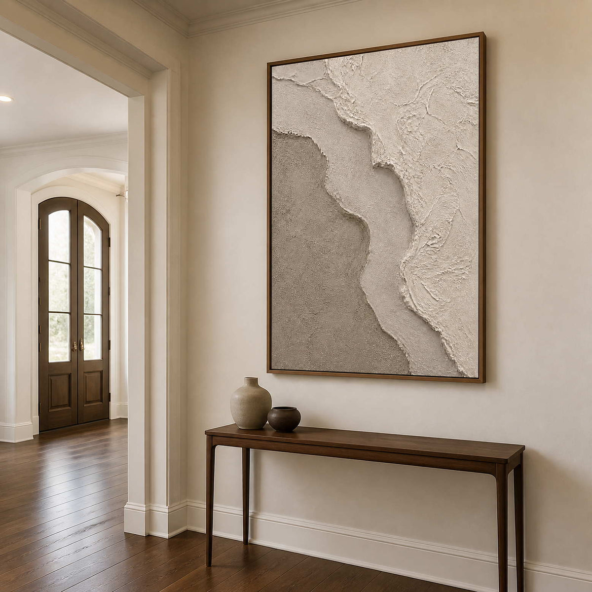 Sculptural neutral wall art in an elegant entryway with a wood frame.