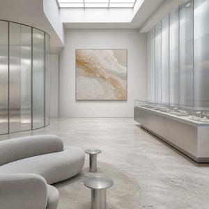 Quiet gold orbits across ivory wall art in a contemporary commercial lobby.
