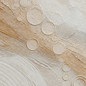 Close-up of the painted texture in quiet gold orbits across ivory.