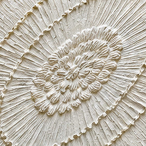 Close-up of finely ridged concentric white and ivory paint texture.
