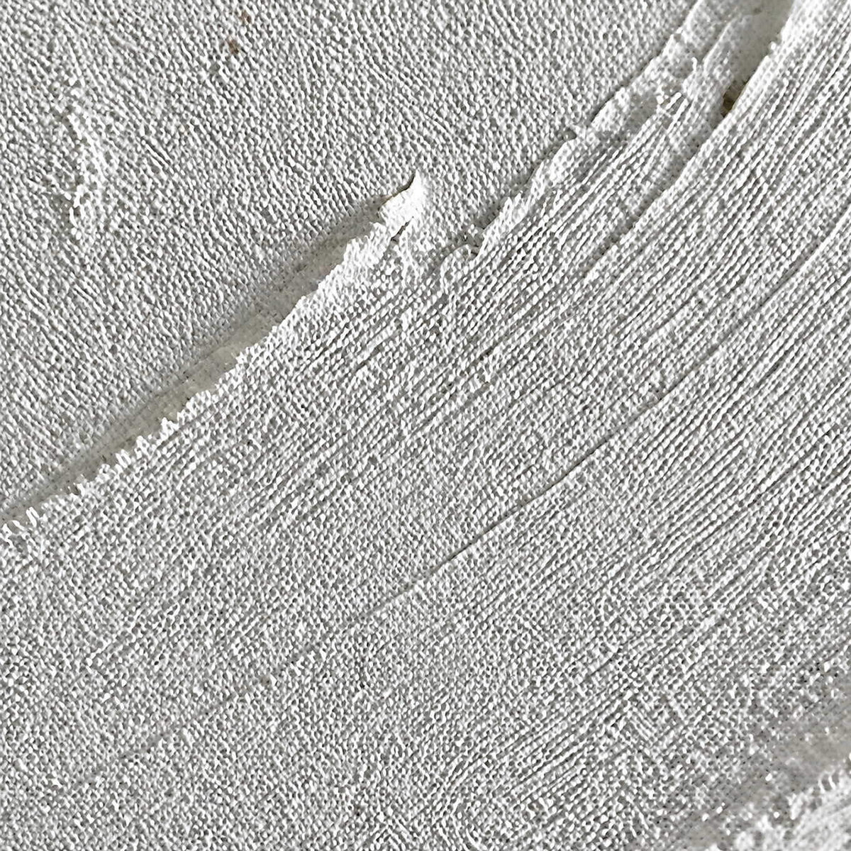 Close-up of raised white circular brushwork and finely layered canvas texture.