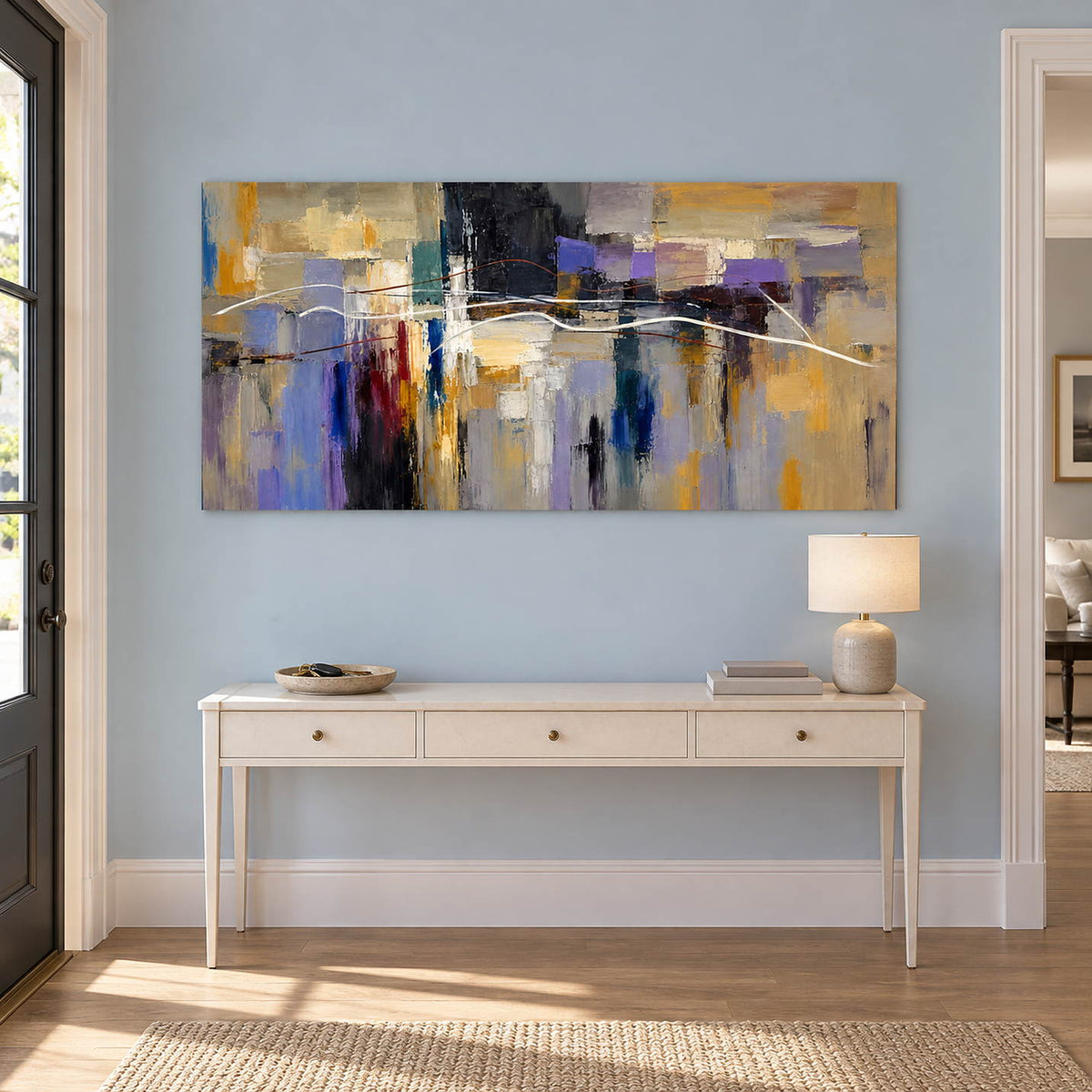 Hand-painted textured abstract wall art in golden ochre, smoky violet, slate blue, and charcoal, displayed in an entrance hall without an outer frame.